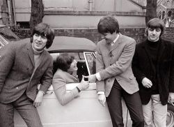  A picture of John Lennon getting his drivers license, and also a car! The other 3 Beatles celebrate in John’s achievement.  