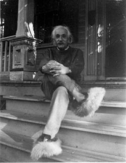 Albert Einstein, wearing fuzzy slippers, relaxing on a porch.