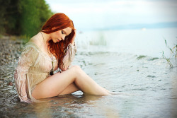 Gorgeous redhead sitting in water, all wet.