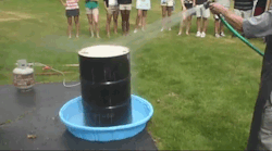 science-gifs:A heated drum is cooled with water. Temperature is proportionate to pressure (PV=NRT), so when the pressure difference between inside and outside is great enough the drum collapses.  