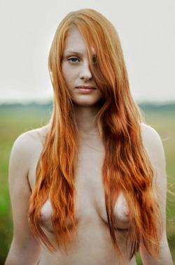 Sexy redhead with long red hair topless outside.