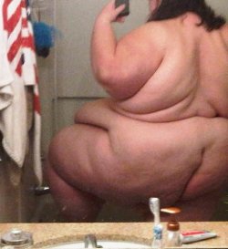 ussbbw:  A candid click, in an undecorated, mundane set, revealing what the mirror shows, but not where my mind goes: a pendulous belly supported by the top of a thigh. But don’t turn around! Please let my hands feel this drooping smoothness before